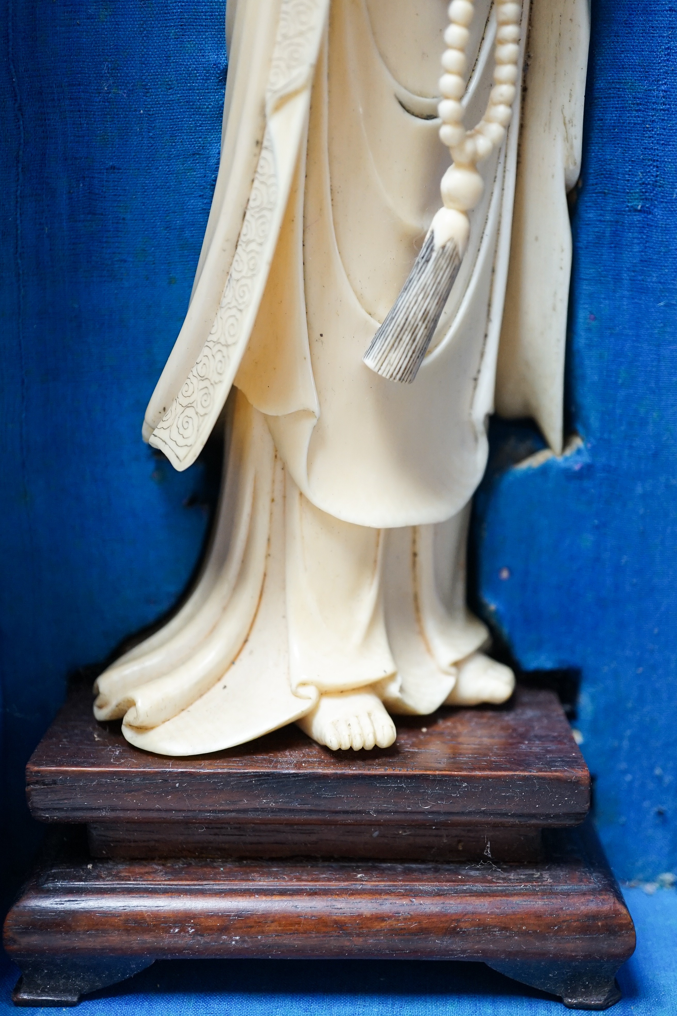 An early 20th century Chinese ivory figure of Guanyin holding a Buddhist rosary 25cm, wood stand and case